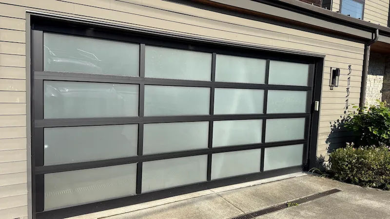 New black and glass garage door on a residential home