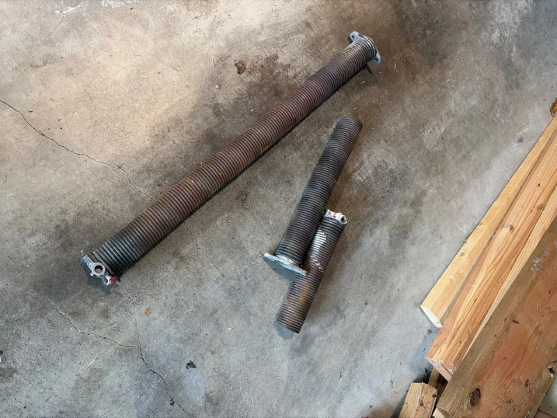 Broken garage door torsion springs removed during a replacement